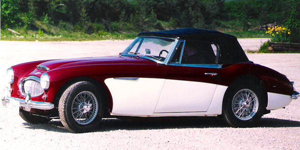 Burgandy over white Austin Healey with roof from the side